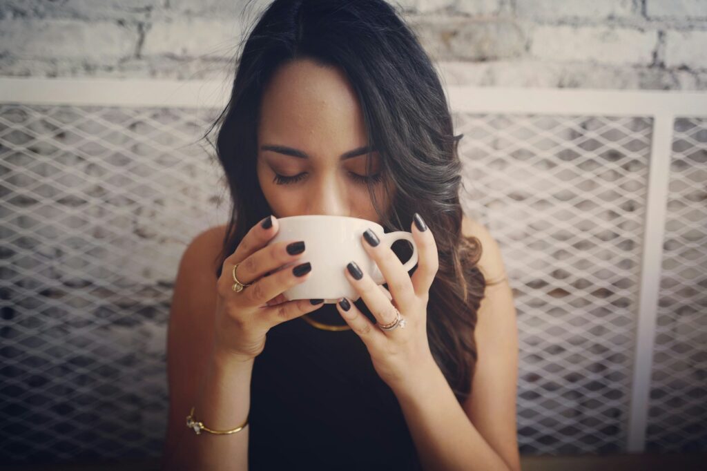 Chica disfrutando de una gran taza de café.
Foto de Drew Coffman en Unsplash